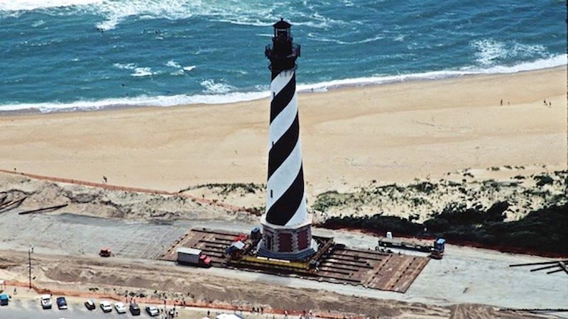 Above:&nbsp;An excellent example of a well-managed strategic retreat from the coast occurred in 1999, when the Cape Hatteras Lighthouse on North Carolina’s Outer Banks was moved 2,900 feet back from an eroding shoreline, a move that cost $12 million. When completed in 1870, the Cape Hatteras lighthouse had been located a safe 1,500 feet inland from the ocean, but natural barrier island erosion processes, augmented by rising seas and storm-driven tides, had reduced this distance to just 120 feet by 1999. Locals were strongly opposed to the move, believing it would harm the tourist industry. Ironically, the lighthouse is now more of a tourist attraction than ever. On the Outer Banks of North Carolina, the regional slope of the land is 1 to 10,000, which means in theory that a 1-foot rise in sea level could move the shoreline about 2 miles. Thus, the lighthouse will likely have to be moved again later this century. Image credit:&nbsp;National Park Service.